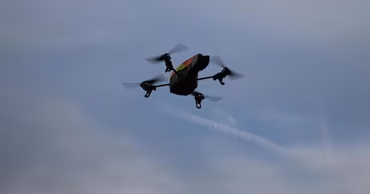 A quadcopter drone flying in the sky.
