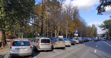 Cars parked along a street in Chisinau with a parking sign visible.
