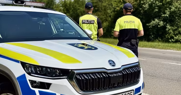 Moldovan police officers standing next to a patrol car on a road.