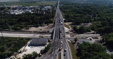 Aerial view of a road construction site with vehicles and machinery.