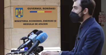 Claudiu Năsui speaking at a press conference in front of the Romanian Ministry of Economy.