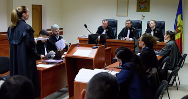 A courtroom scene in Moldova with judges and lawyers during a legal hearing.