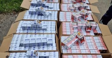 Multiple cardboard boxes filled with packs of cigarettes confiscated by authorities.