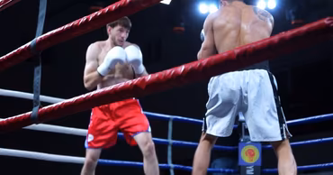 Two boxers in a ring during a professional boxing match.