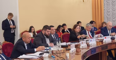 Grigore Uzun and other Moldovan politicians sitting at a conference table during a meeting.