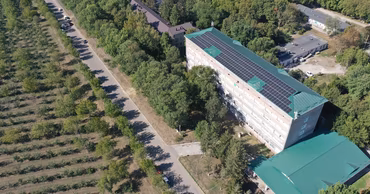 Aerial view of a hospital building with solar panels installed on the roof.