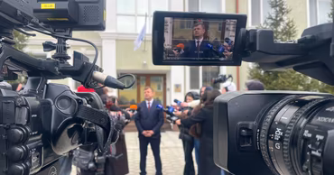 Vitaly Ignatiev speaking to journalists in front of cameras during a press briefing.