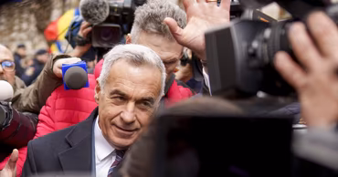 Călin Georgescu surrounded by journalists and cameras.