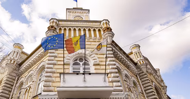 The Chisinau City Hall building with Moldovan and European Union flags flying.