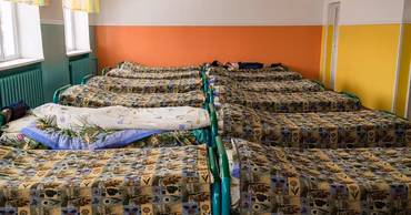 A dormitory room with multiple beds in a residential care facility for people with disabilities.