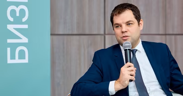 Dorin Jungietu speaking into a microphone at a business event.