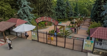 Aerial view of the entrance gate to the Chisinau Zoo with visitors walking nearby.