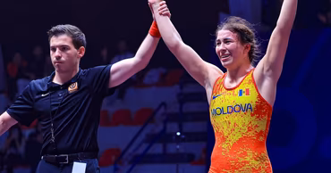 Moldovan wrestler Irina Rîngaci celebrating a victory with a referee raising her hand.