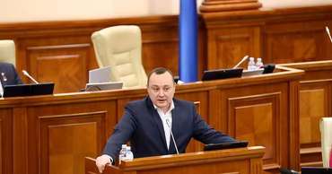 Vlad Batrincea speaking from the podium in the Parliament of Moldova.