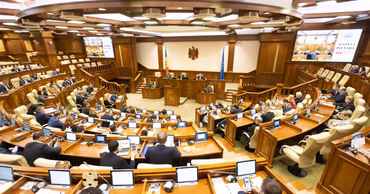 A wide-angle view of the Moldovan Parliament plenary session hall with deputies at their desks.