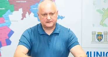 Igor Dodon sitting at a table in front of a map.