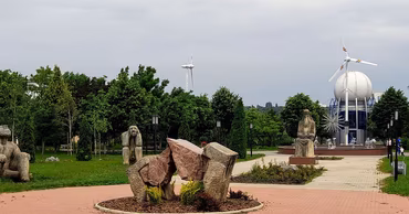 The campus grounds of the Technical University of Moldova in Chisinau with sculptures and a wind turbine.