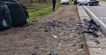 A car accident scene with a damaged vehicle on the side of the road.
