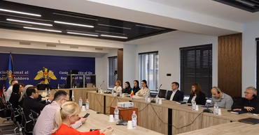 A group of people sitting at a conference table in a Moldovan Customs Service office.