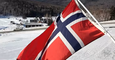The flag of Norway waving in a snowy landscape.