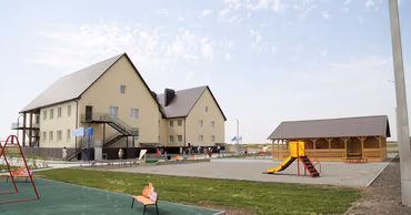 A modern kindergarten building with a playground in the village of Bubuieci, Moldova.