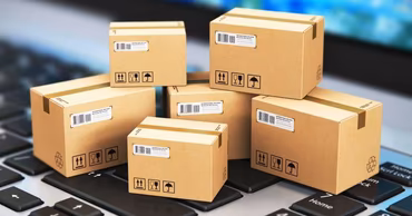 Cardboard shipping boxes placed on a computer keyboard representing online shopping.