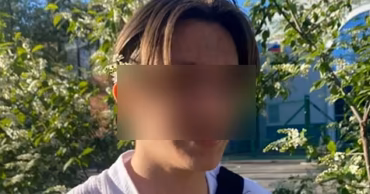 A portrait of a young male teenager with blurred face outdoors.