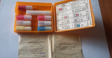 An open orange Soviet-era individual medical kit with various medication tubes and instructions.