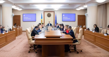Moldovan government officials attending a formal meeting in the cabinet room.