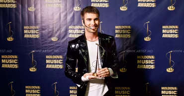 Ionel Istrati holding an award at the Moldova Music Awards.