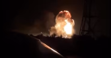 A night shot of a large explosion with fire and smoke.