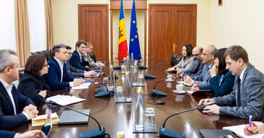 Moldovan government officials and representatives in a meeting room discussing infrastructure projects.