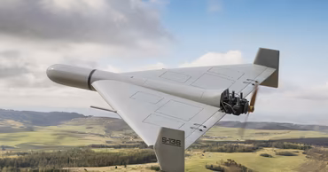A Geran-type kamikaze drone flying over a landscape.