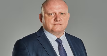 Portrait of Dmitri Vangheli wearing a suit and tie.