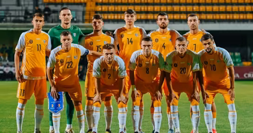 The Moldovan national football team posing for a group photo on the pitch.