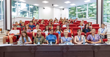 A group of young students sitting in a modern university lecture hall.