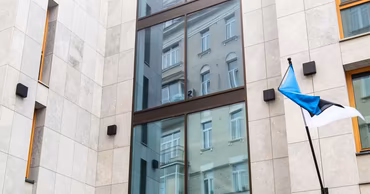 The exterior of the Estonian embassy building with an Estonian flag displayed on the wall.