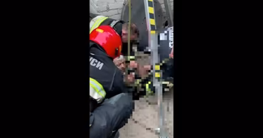 Moldovan rescuers from GIGS pulling a man out of a well.