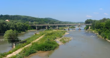 A view of the Prut river with a bridge and low water levels.