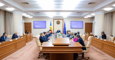 A wide shot of a Moldovan government meeting in a conference room.