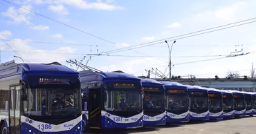 A row of blue Chisinau public transport trolleybuses parked at a depot.