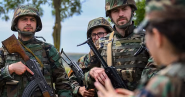 Moldovan soldiers in camouflage uniforms holding rifles during a training exercise.