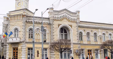 The historic Zarea building in downtown Chisinau with pedestrians walking in front of it.