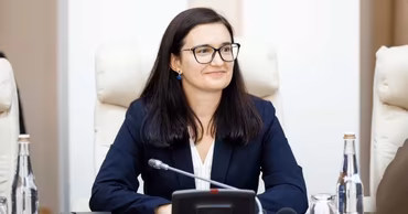 Mihaela Fedoseev sitting at a conference table in an office setting.