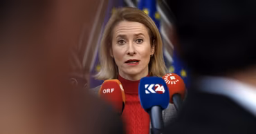 Kaja Kallas speaking at a press conference with microphones in front of her.