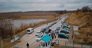 Aerial view of a Moldovan border crossing point with cars and people waiting.