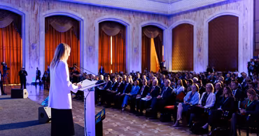 A speaker at a podium addressing an audience at a formal security conference in Moldova.