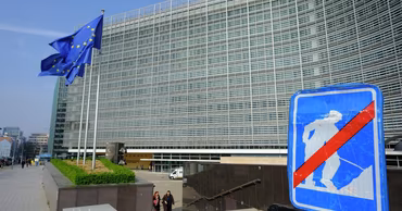 The Berlaymont building, headquarters of the European Commission in Brussels, with EU flags flying.