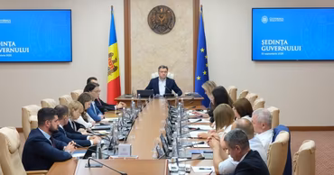Moldovan Prime Minister chairing a government meeting with officials around a conference table.