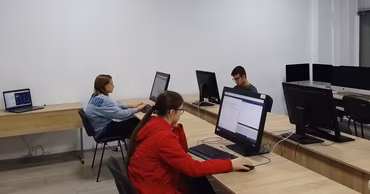 Students sitting at desks in a computer lab working on desktop computers.
